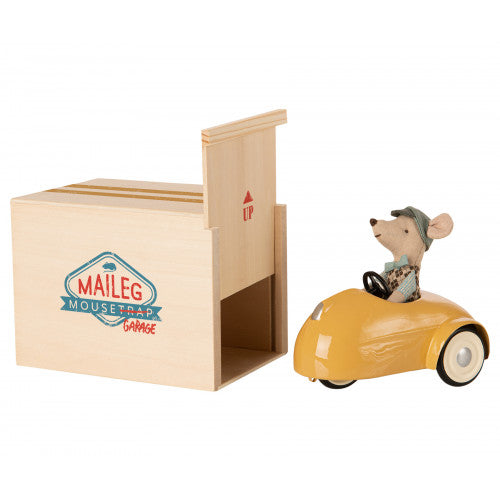 Myszka w retro samochodzie z drewnianym garażem